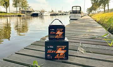 2 LiTime 50ah trolling motor batteries stacked on a peaceful dock in a marina, ready for boating season
