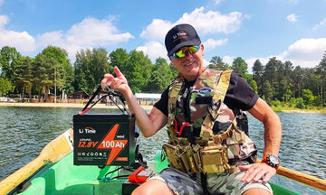 a man hoding a litime 100ah mini stting in a boat showing its lightweight