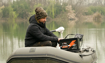 A man sits in his kayak and a litime 12v 100ah lifepo4 battery powering the trolling motor