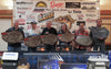 Walleye Fall Brawl winners with their plaques and LiTime batteries in front of sponsor banners