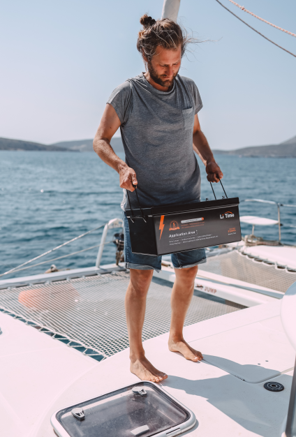 a man on the boat carrying a litime lithium battery showing its lighweight feature