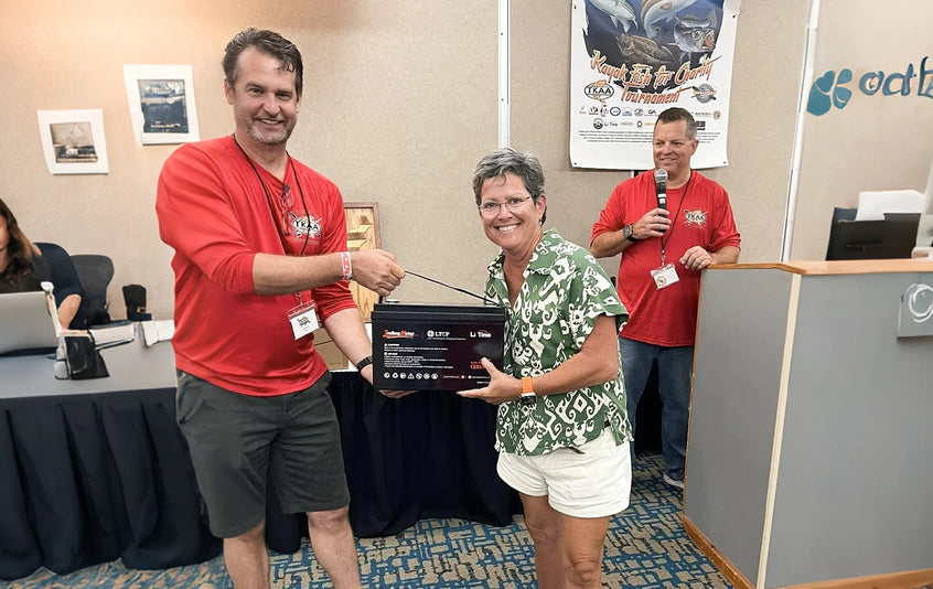 a smiling man is awarded a LiTime battery prize at the Heroes on the Water event
