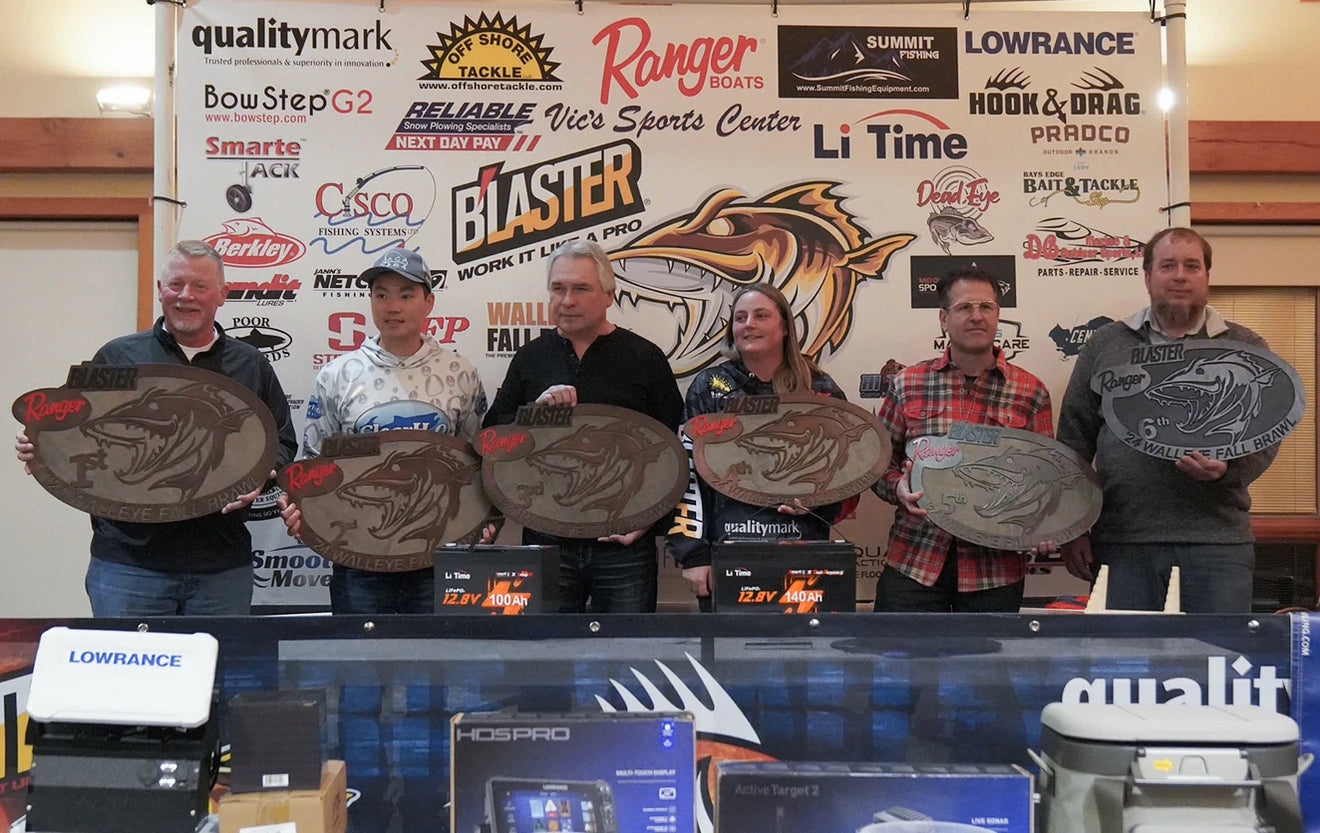 Walleye Fall Brawl winners with their plaques and LiTime batteries in front of sponsor banners