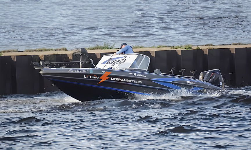 A bass boat with a trolling motor moving at speed across the water, representing a common application for the battery